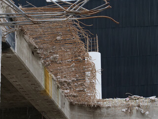 Demolition work on a construction site with concrete pillars, steel beams, etc.