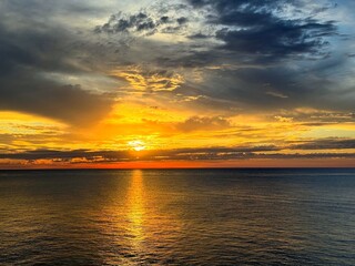 Sunset in the dramatic sky over dark sea. 