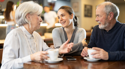 Family participants relatives sitting in cafe, talking, drinking coffee and having nice...