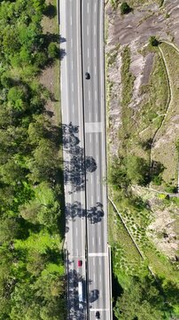 Vis&atilde;o a&eacute;rea de rodovia com fluxo constante de ve&iacute;culos, evidenciando infraestrutura de transporte, mobilidade regional e conex&atilde;o entre centros urbanos.