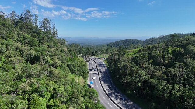 Rodovia cortando mata cont&iacute;nua e &aacute;reas verdes, destacando mobilidade, conex&atilde;o territorial e a presen&ccedil;a dominante da vegeta&ccedil;&atilde;o no entorno da infraestrutura vi&aacute;ria.