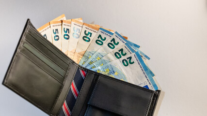 Wallet with euro banknotes on a white background, representing the concept of monetary outlay, expenses, taxes, bills, and the high cost of living. Financial and economic concept image.