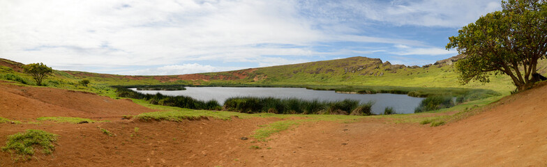 Rano Raraku crater lake with greenery, clear skies, Easter Island