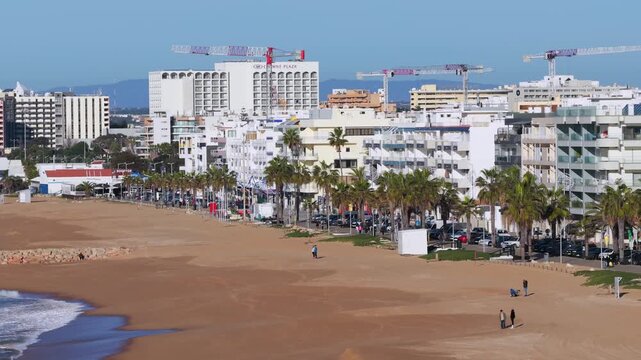 Golden Algarve Sunrise: Cinematic 4K Aerial of Quarteira Featuring Beachfront High-Rise Apartments, the Cal&ccedil;ad&atilde;o Promenade, and the Atlantic Horizon, Portugal