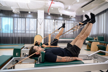 Men and women strengthen muscles to maintain physical health. Couple enjoying pilates classes in fitness studio.