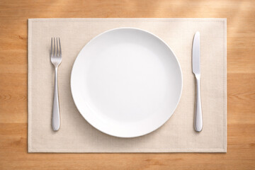 白い皿とカトラリーをランチョンマットに並べた白木テーブル　食事イメージ用背景