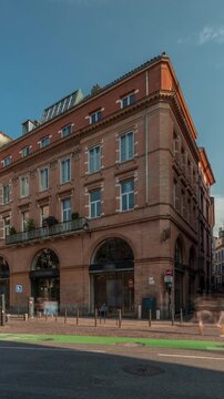 Panorama showing Rue de Metz timelapse in Toulouse, Occitanie, France, with historic facades, shops, cafes, traffic and a blue cloudy sky. Vibrant urban scene in the heart of the city