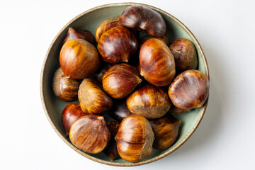 Obraz premium Raw chestnuts in bowl top view