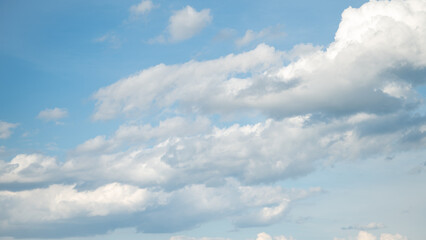 Bright blue sky with fluffy white clouds creating a peaceful natural background and scenic summer atmosphere