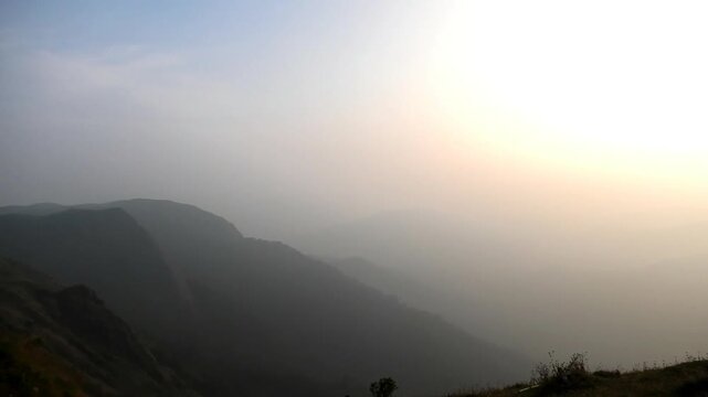 The panoramic landscape of Parunthumpara, Idukki, Kerala, India covered in heavy fog at dusk