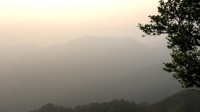 The panoramic landscape of Parunthumpara, Idukki, Kerala, India covered in heavy fog at dusk