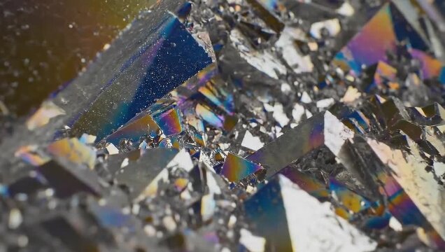 Macro closeup of iridescent pyrite crystal structure with sharp geometric facets and colorful metallic sheen