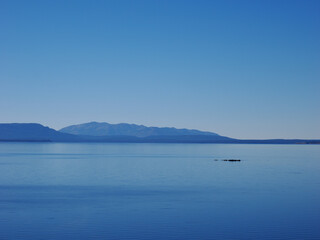 Calm Blue Waters of Yellowstone Lake Against Mountain Skyline