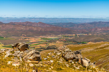 A view past a rocky outcrop beside the Swartberg pass across the Swartberg mountains in South Africa in springtime