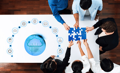Diverse team gathers around a table to connect puzzle pieces, symbolizing collaboration and...