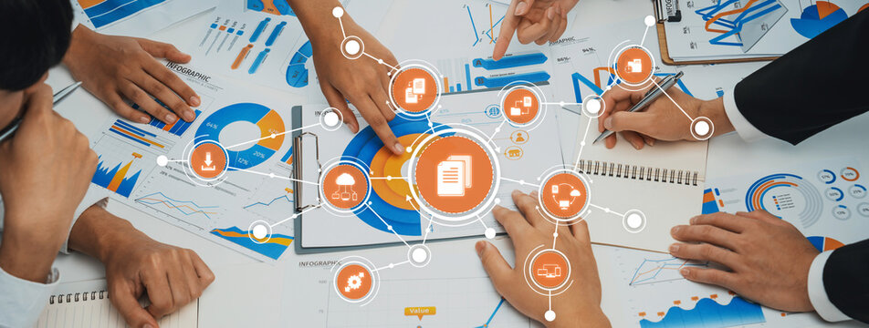 A dynamic workspace featuring a diverse team engaged in a collaborative business strategy session, utilizing charts, diagrams, and digital resources to drive innovation. Amity - Powered by Adobe