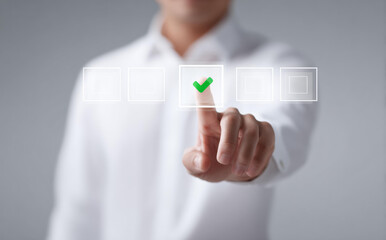 Businessman in white shirt touching virtual interface screen with green check mark confirming correct choice and approval showing positive success decision