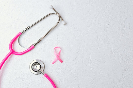 Stethoscope and ribbon on white background for breast cancer awareness - Powered by Adobe