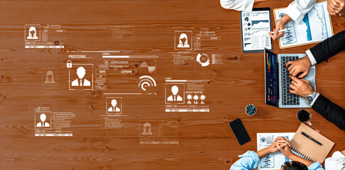 Business professionals engage in a collaborative meeting analyzing data and statistics using...