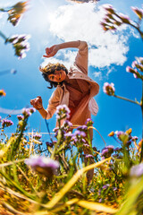 Happy woman enjoying nature outdoors among flowers. Outdoors.
