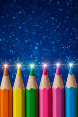 A row of brightly sharpened pencils with shimmering light effects on the tips. Against a deep blue background with shimmering bokeh circles.