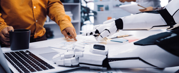 A modern office scene featuring a collaboration between a human and a robot, showcasing technology and innovative ideas in a productive business environment.Noogenesis