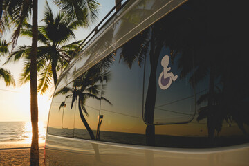 A wheelchair accessible van parked near the seaside with reflections of trees and the ocean. The image represents inclusive transportation, mobility support, accessible travel, and freedom of movement