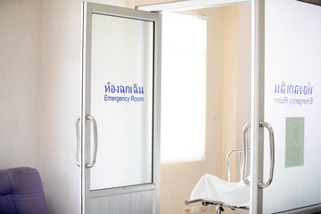 he sign above the door reads "Emergency Room" in both Thai and English. The scene highlights urgency, teamwork, and patient care in a hospital setting.