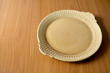 Elegant empty dish on a wooden table waiting for a delicious meal