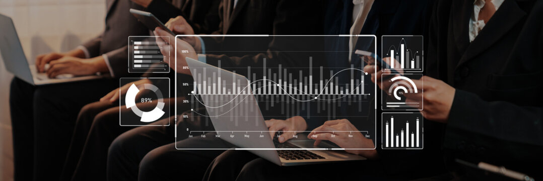 A group of business professionals focus on digital analysis using laptops and mobile devices, showcasing graphs and charts that represent data trends and insights. Trope - Powered by Adobe