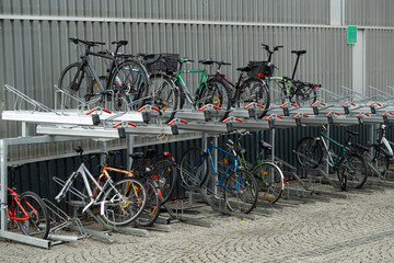 Obraz premium Double-decker bicycle parking with various bicycles in an urban environment