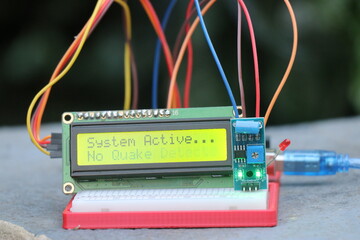 LCD module or liquid crystal display connected to breadboard and sensor module showing some words on the display board controlled by controller