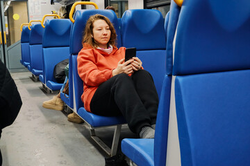 Woman riding public transport, relaxing and using her mobile phone on daily commute