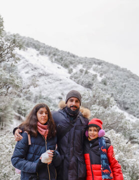 Bearded Father Aged Forty Posing with His Twelve Year Old Daughter and Ten Year Old Son in a Snowy Forest on a Winter Day