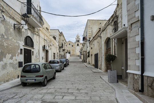 Typical buildings along a narrow street in Vieste&rsquo;s old town, partly built on cliffs, bustling with tourists on the Mediterranean coast of Gargano, Apulia, Italy.
