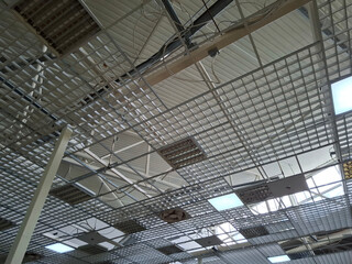 Ceiling and metal roof in a shopping center with ventilation and electric lamps