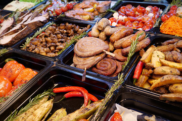 Various foods - sausages and frankfurters, fried potatoes, vegetables