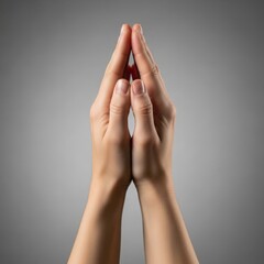 Two hands pressed together in a prayer or pleading gesture against a soft grey background, conveying reverence and supplication.