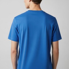 Rear view of a man in a classic blue t-shirt, showcasing a simple, clean silhouette against a studio backdrop.