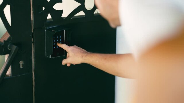 Close up view of a person's hand entering a password on a modern electronic keypad. Concept of home security, access control, and privacy