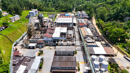 Vista a&eacute;rea de planta petroqu&iacute;mica em meio a &aacute;reas verdes destaca o contraste entre natureza preservada e a escala da produ&ccedil;&atilde;o industrial.