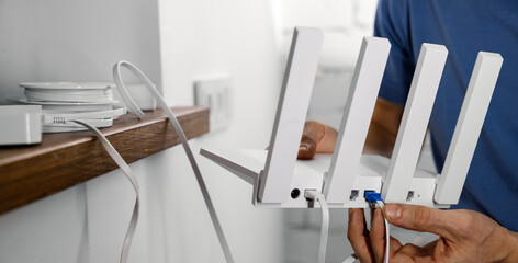 Wireless internet. Service provider technician plug in cables in Wi-Fi router. copy space