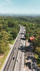 Vista vertical a&eacute;rea de estrada na serra de Mogi das Cruzes revela uma importante liga&ccedil;&atilde;o rodovi&aacute;ria entre o interior paulista e as praias do litoral.