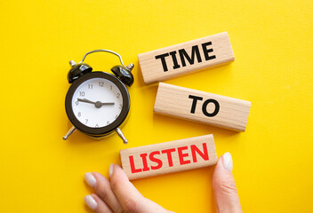 Time to listen symbol. Concept words Time to listen on wooden blocks. Businessman hand. Beautiful yellow background with alarm clock. Business and Time to listen concept. Copy space.