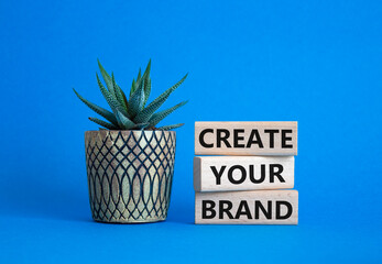 Brand symbol. Concept words Create your Brand on wooden blocks. Businessman hand. Beautiful blue background with succulent. Business and Create your Brand concept. Copy space.