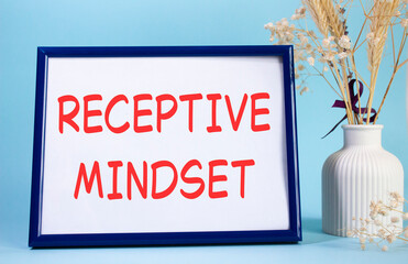 Receptive Mindset symbol. Concept words Receptive Mindset on beautiful wooden picture frame. Beautiful light blue background with flower vase. Business and Receptive Mindset concept. Copy space.