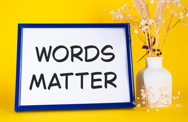 Words Matter symbol. Concept words Words Matter on beautiful wooden picture frame. Beautiful yellow background with flower vase. Business and Words Matter concept. Copy space.