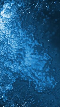 Vertical Blue Lumpy Glass Morph 4K Loop features a heavily textured glassy blue surface moving and morphing in a vertical ratio loop.