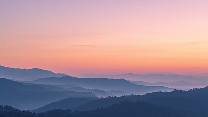 Obraz premium A serene mountain landscape at sunset with rolling hills and a vibrant sky