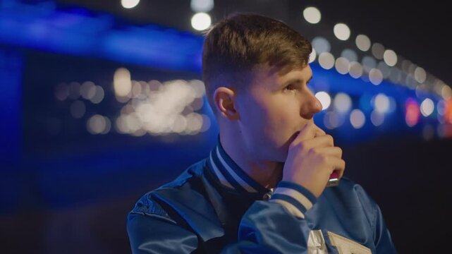 white man vaping under neon bridge lights, latenight commuter pausing to inhale, closeup profile with blue bokeh, smoke plume drifting across face, bomber jacket, cinematic lonely mood, empty